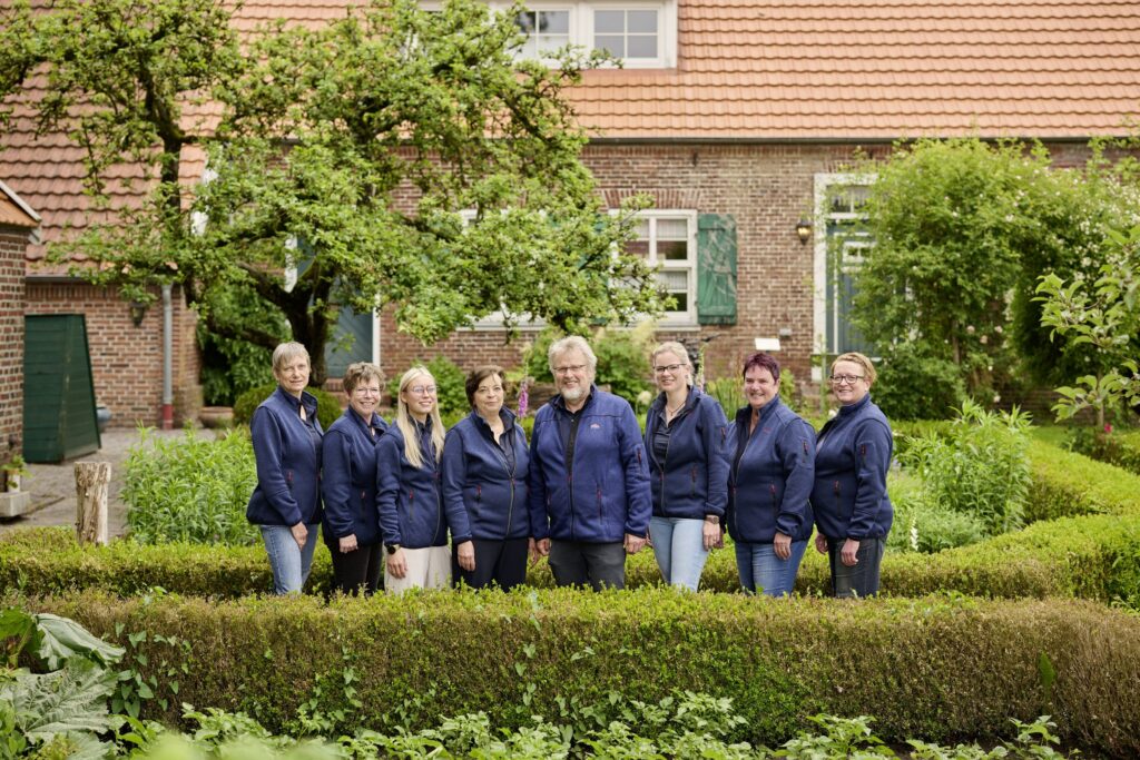 Team der Tierarztpraxis steht im Garten und schaut in die Kamera